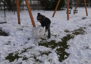 chłopiec formuje kulę ze śniegu
